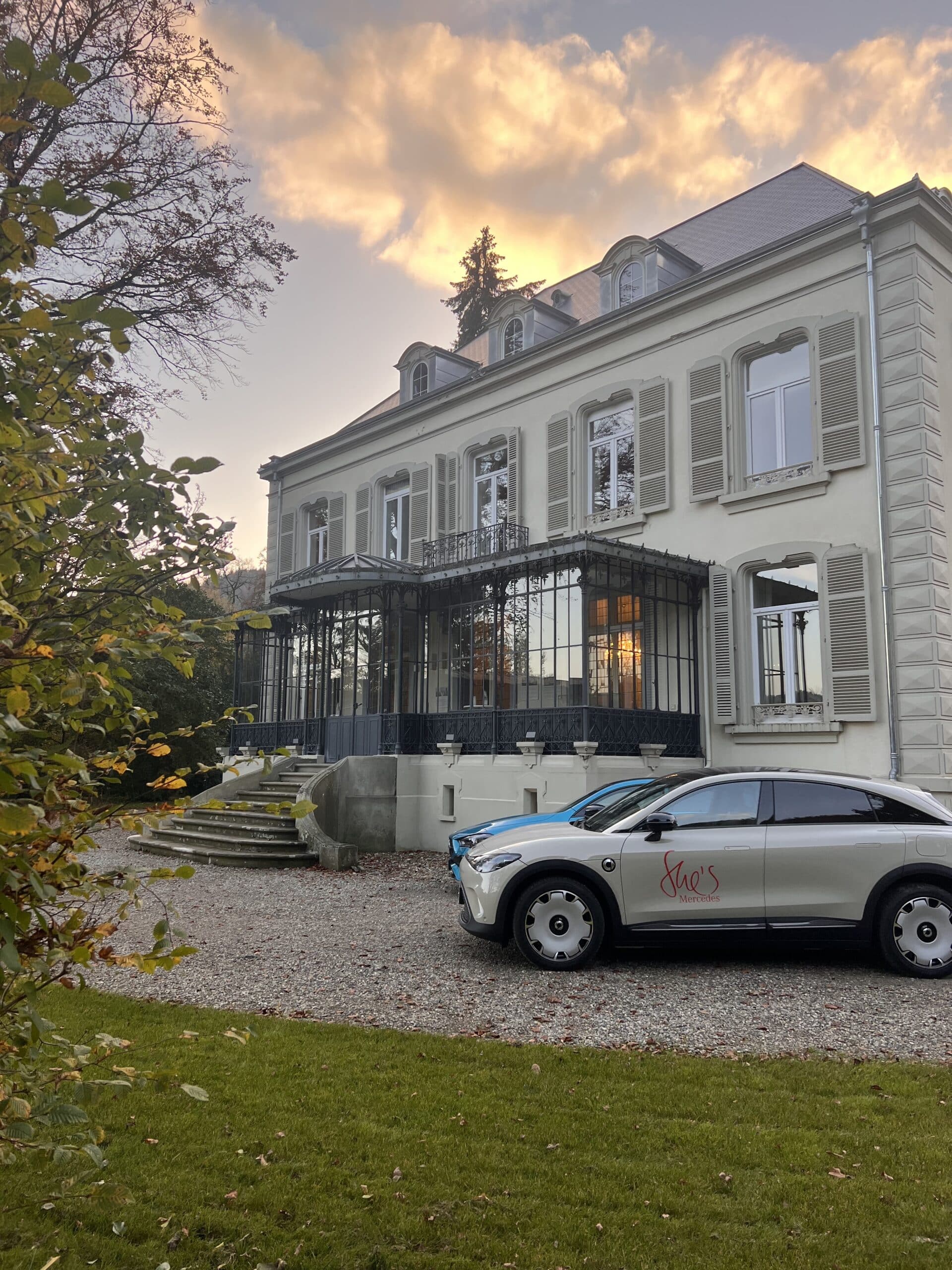 Façade de la Villa des Hêtres Pourpres avec véhicules Mercedes lors d’un événement partenaire.