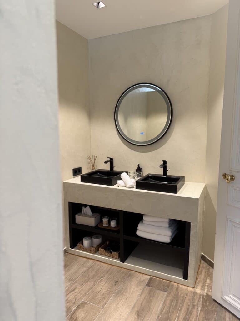Salle de bain moderne avec double vasque noire et rangements intégrés.