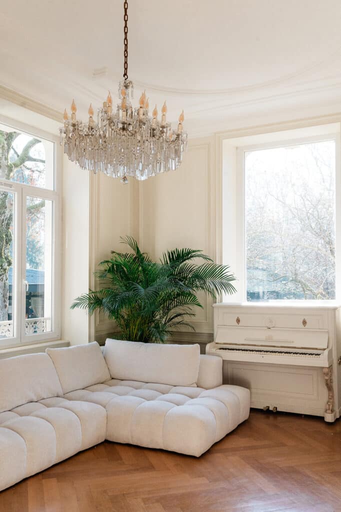 Salon lumineux avec canapé moderne et piano blanc dans la Villa des Hêtres Pourpres.