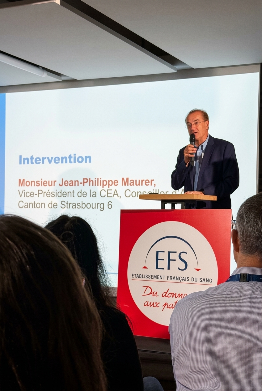 améliore la qualité de limage – La villa des hêtres pourpres Speaker at a podium giving a presentation; slide reads 'Intervention' and mentions Jean-Philippe Maurer by name.